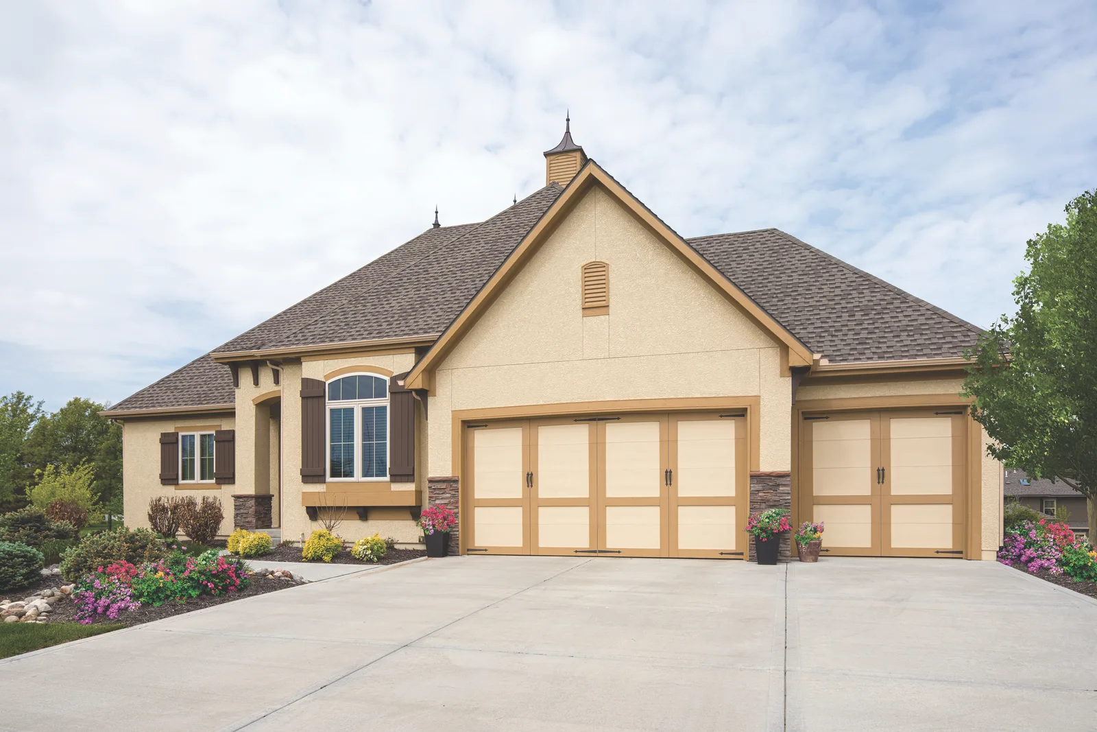 Three-car garage with tan raised panel doors